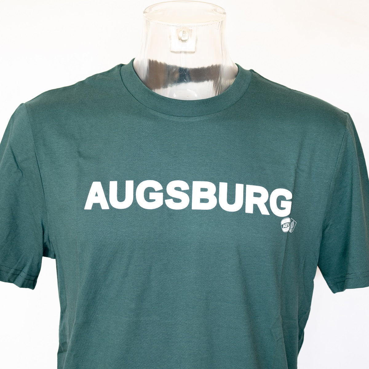 Nahaufnahme des "AUGSBURG" Schriftzuges auf Brusthöhe