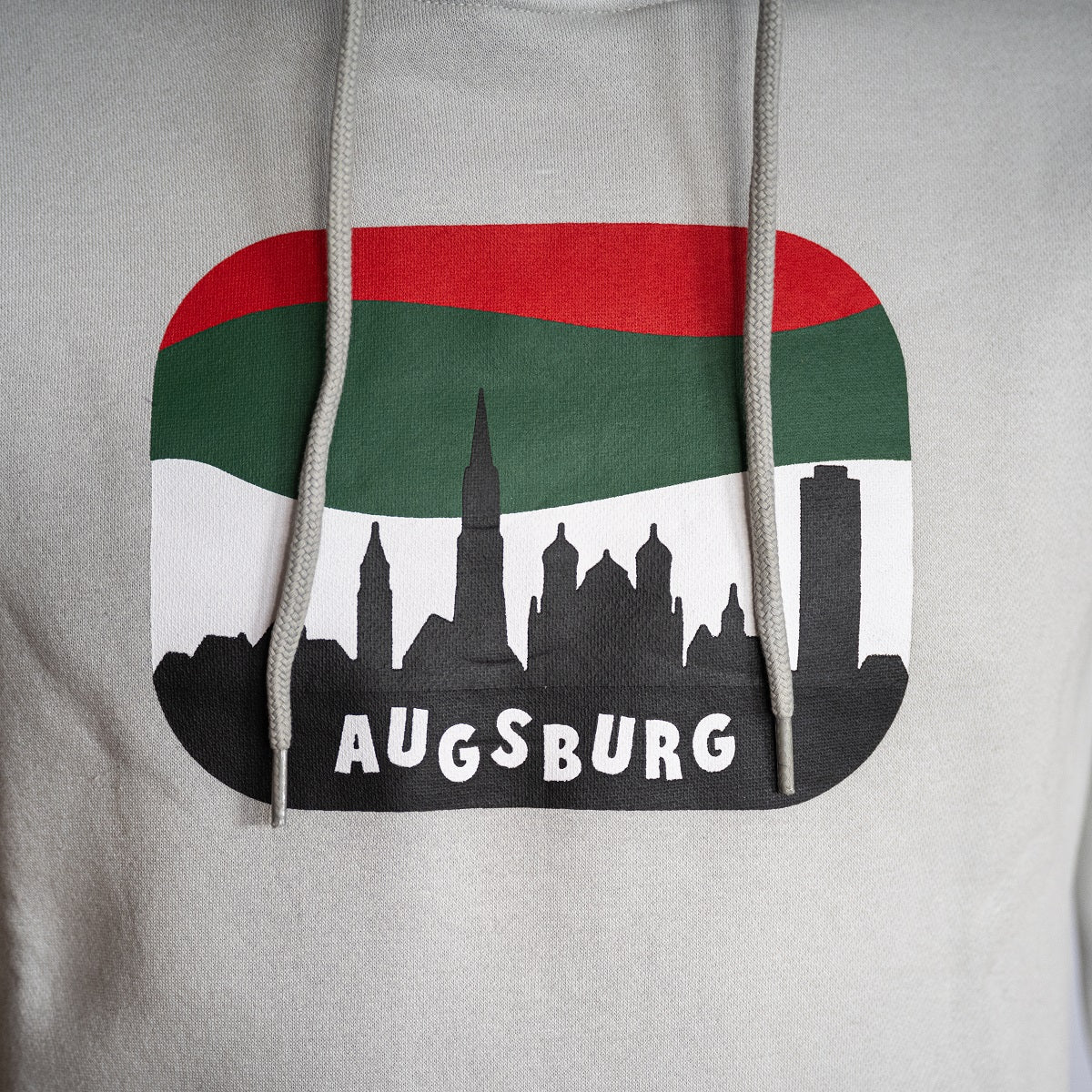Nahaufnahme des Skyline-Motivs Augsburgs, der Horizont hinter der Skyline ist rot-grün-weiß